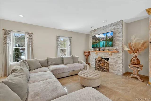 a living room with furniture a flat screen tv and a window