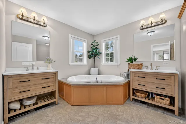 a spacious bathroom with a granite countertop sink mirror and bathtub