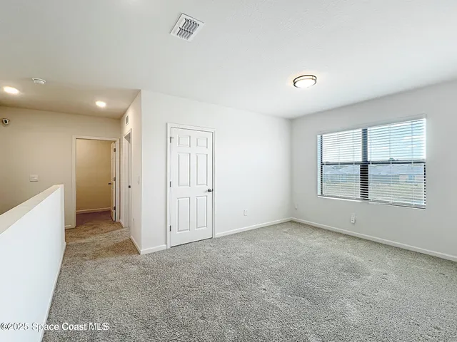 an empty room with windows and closet