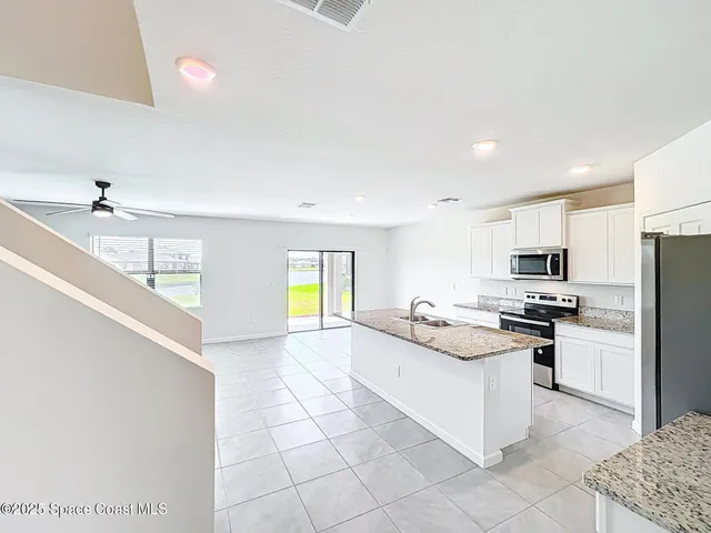 a kitchen with stainless steel appliances granite countertop a sink and a stove