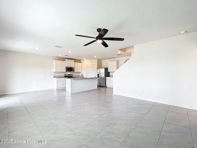 a view of kitchen with a sink a refrigerator and window