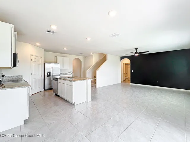 a view of kitchen with cabinets and refrigerator