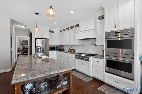 a kitchen with stainless steel appliances granite countertop a stove a refrigerator and a stove