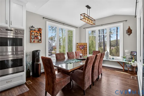a dining room with furniture a chandelier and wooden floor