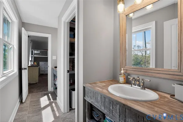 a en suite bathroom with a granite countertop sink and a mirror