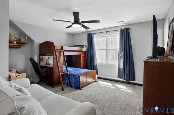 a living room with furniture a ceiling fan and a window