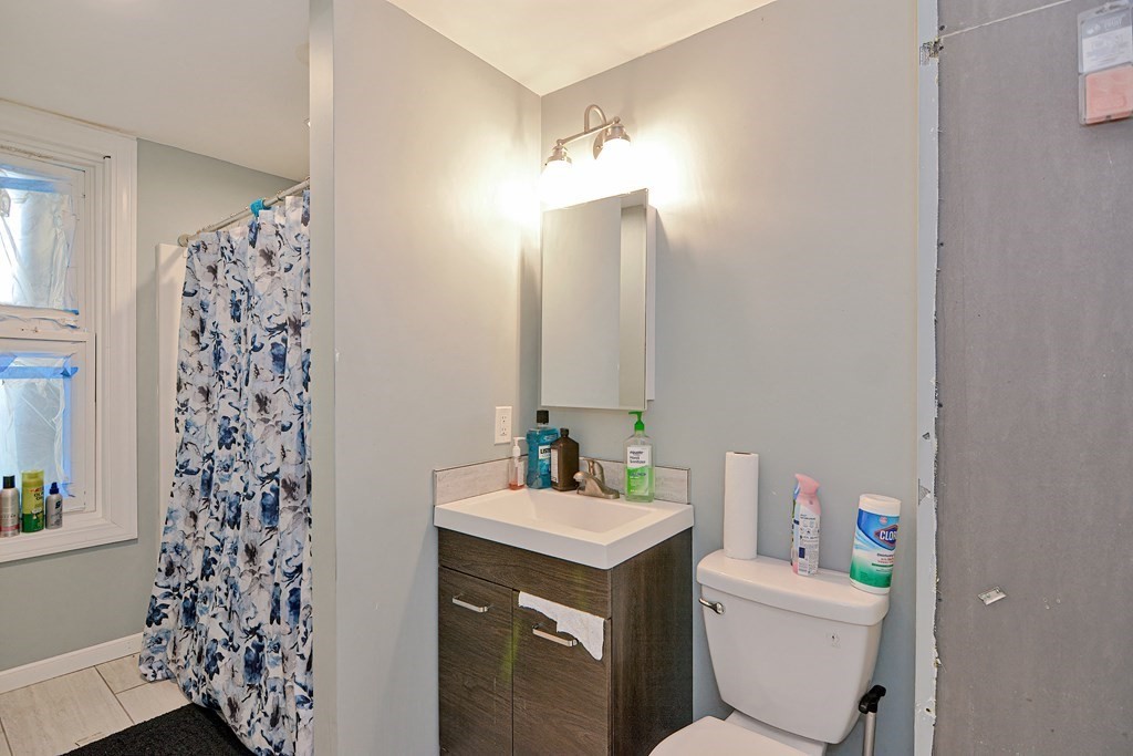 83 Ward Street Worcester, MA 01610 - Photo 14 of 28 a bathroom with a sink a toilet and shower curtain