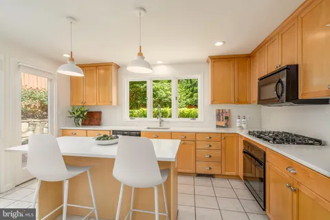 a kitchen with stainless steel appliances granite countertop a stove a sink a microwave a refrigerator and cabinets