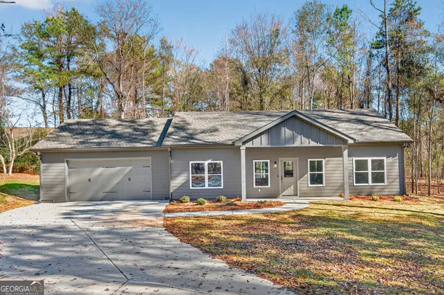 a front view of a house with a yard and trees