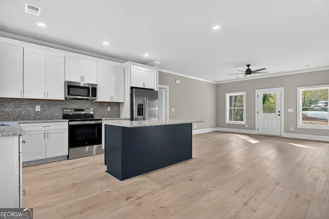 a kitchen with granite countertop a refrigerator and a stove top oven