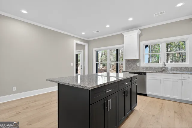 a kitchen with granite countertop a sink and cabinets