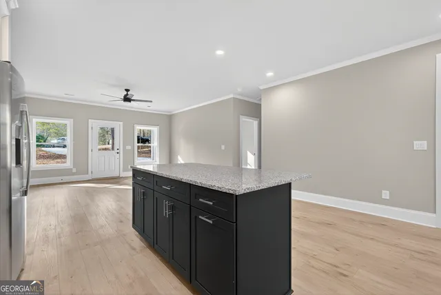 a hall with kitchen island a sink wooden floor and living room view