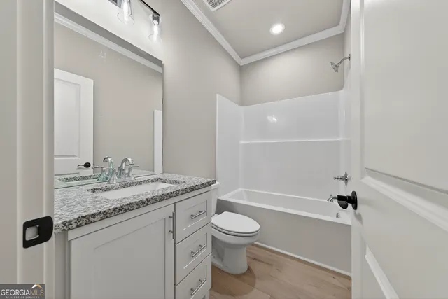 a bathroom with a granite countertop sink toilet mirror and bathtub