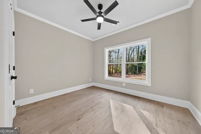 an empty room with window and a ceiling fan