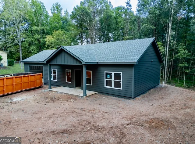 a view of a house with a yard and large tree