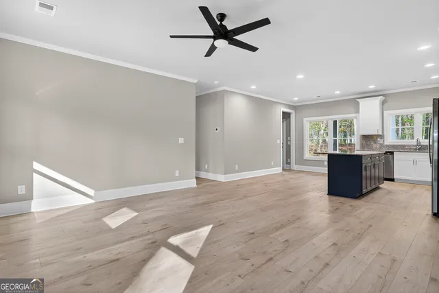a view of an empty room with a window and wooden floor