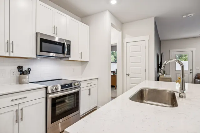 a kitchen with stainless steel appliances granite countertop a sink stove and microwave