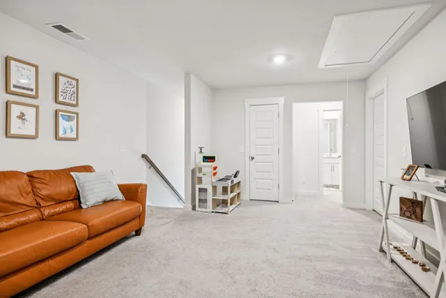a bedroom with a bed and a flat tv screen on the dresser