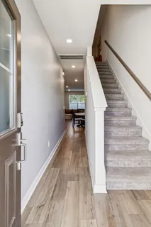 a view of a hallway with wooden floor and staircase