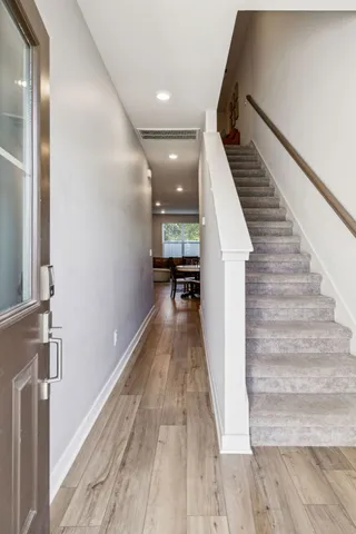 a view of a hallway with wooden floor and staircase