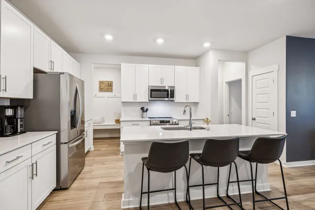 a kitchen with stainless steel appliances a sink stove refrigerator and cabinets
