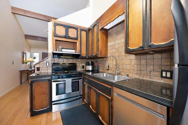 a kitchen with stainless steel appliances granite countertop a sink and a stove