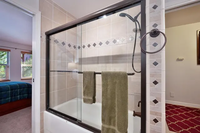 a bathroom with a glass shower door and a mirror