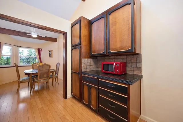 a kitchen view with table chairs and wooden floor