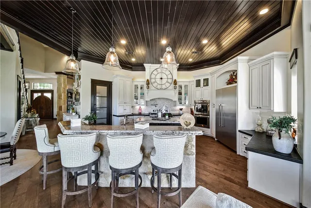 a large kitchen with stainless steel appliances granite countertop a stove and a sink