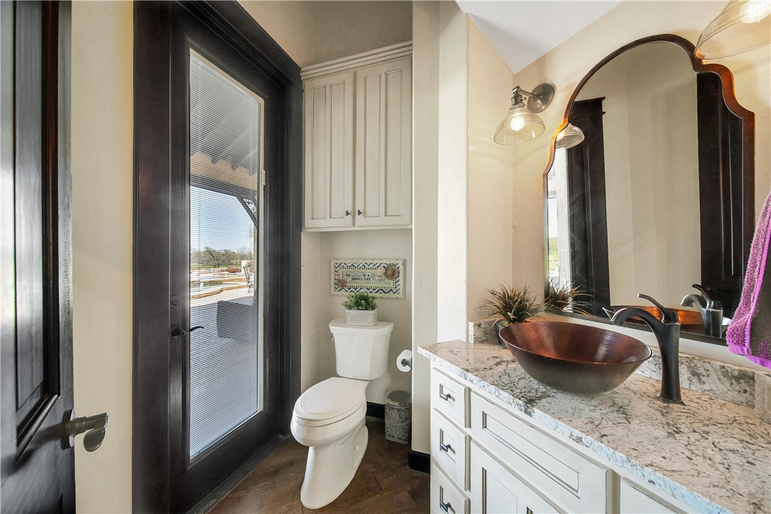 2289 Old Dobbin Road Montgomery, TX 77316 - Photo 24 of 50 a bathroom with a granite countertop sink a toilet and a mirror