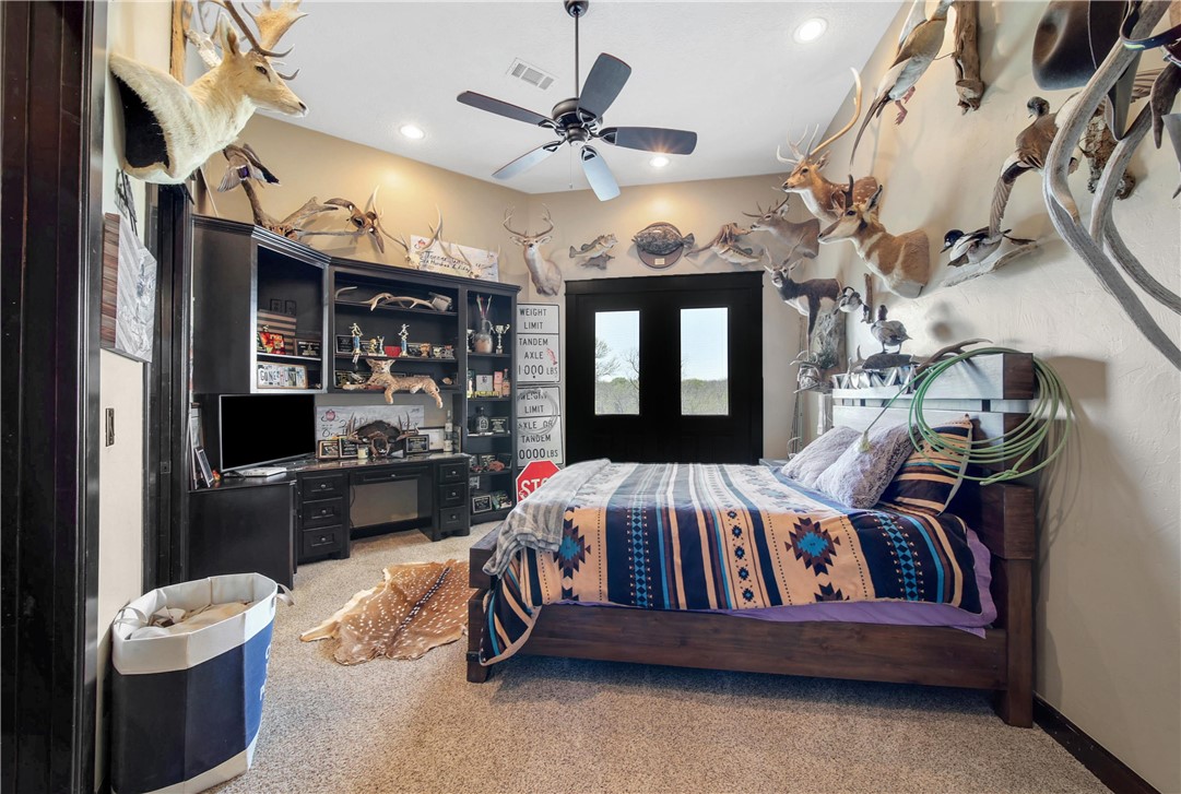 2289 Old Dobbin Road Montgomery, TX 77316 - Photo 25 of 50 a bedroom with a bed and a chandelier