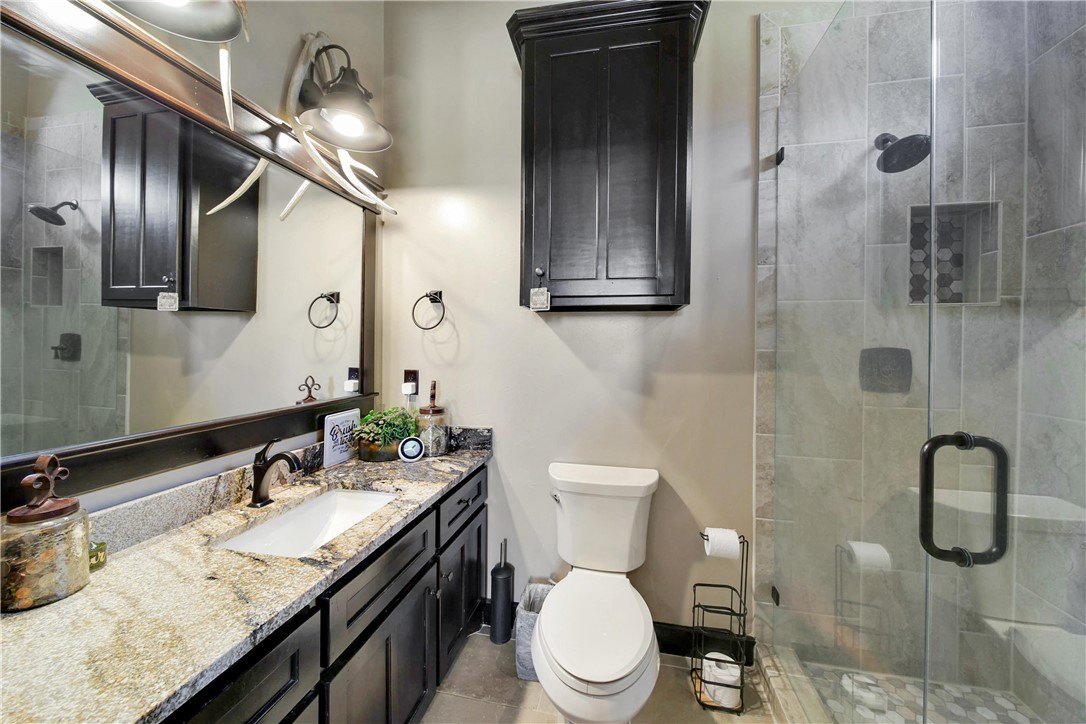2289 Old Dobbin Road Montgomery, TX 77316 - Photo 26 of 50 a bathroom with a granite countertop sink a toilet and mirror
