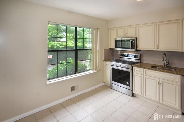 a kitchen with white cabinets stainless steel appliances and sink