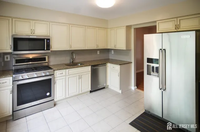 a kitchen with cabinets stainless steel appliances and a counter space