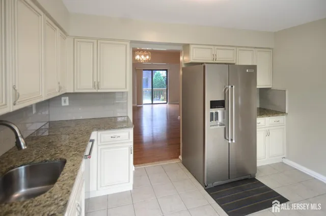 a kitchen with granite countertop a refrigerator and a sink