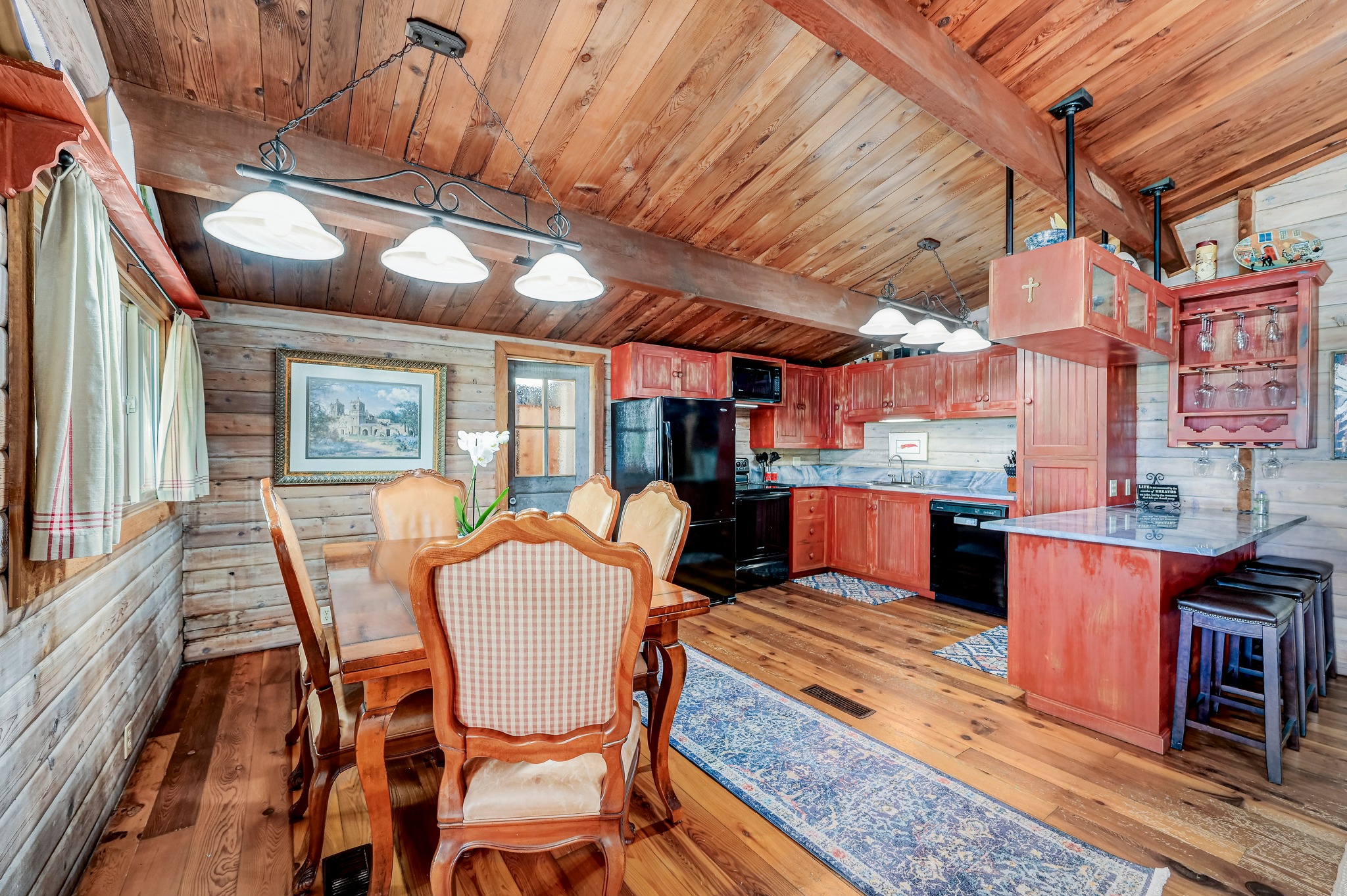 900 Box Canyon Road Wimberley, TX 78676 - Photo 15 of 40 Dining room featuring wood walls, light wood-pine flooring and vaulted wood ceiling.