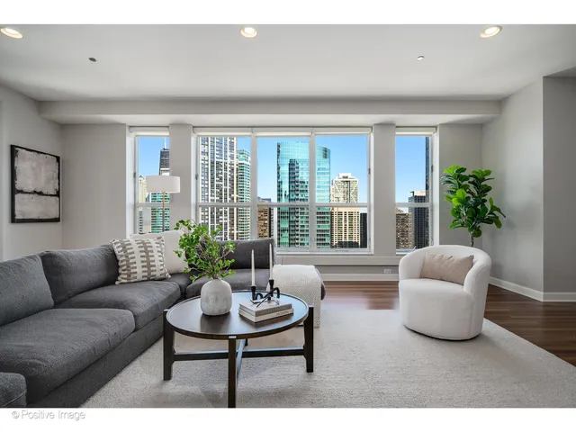 a living room with furniture and floor to ceiling windows