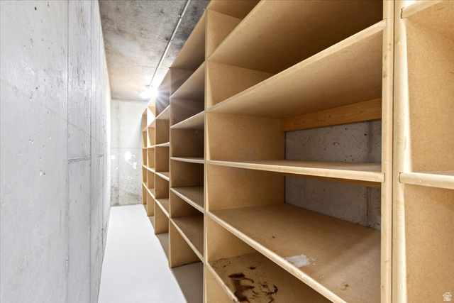 1676 East 11245 South Sandy, UT 84092 - Photo 30 of 34 Built-in shelving system with multiple compartments, concrete walls, concrete ceiling, and light-toned flooring