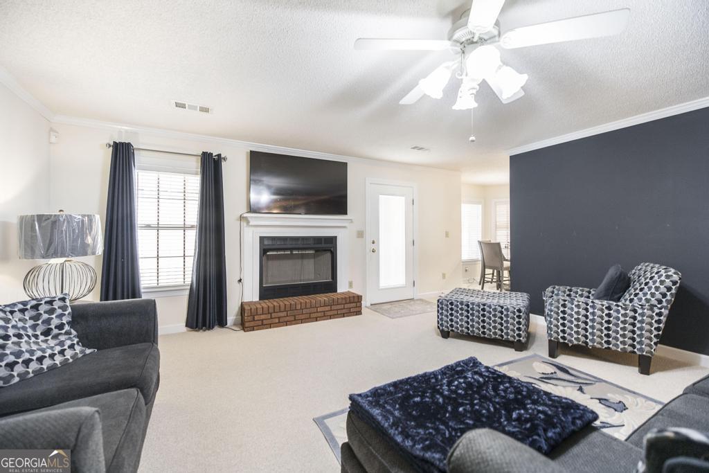 201 Strawberry Circle Dublin, GA 31021 - Photo 22 of 40 a living room with furniture a fireplace and a flat screen tv