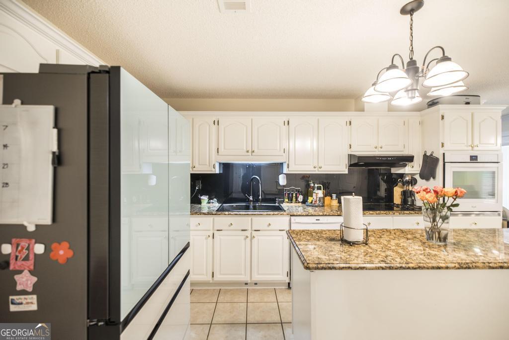 201 Strawberry Circle Dublin, GA 31021 - Photo 26 of 40 a kitchen with stainless steel appliances granite countertop a sink refrigerator and cabinets
