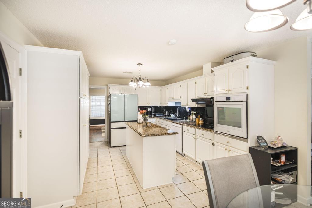 201 Strawberry Circle Dublin, GA 31021 - Photo 29 of 40 a kitchen with stainless steel appliances kitchen island granite countertop a refrigerator and a stove top oven