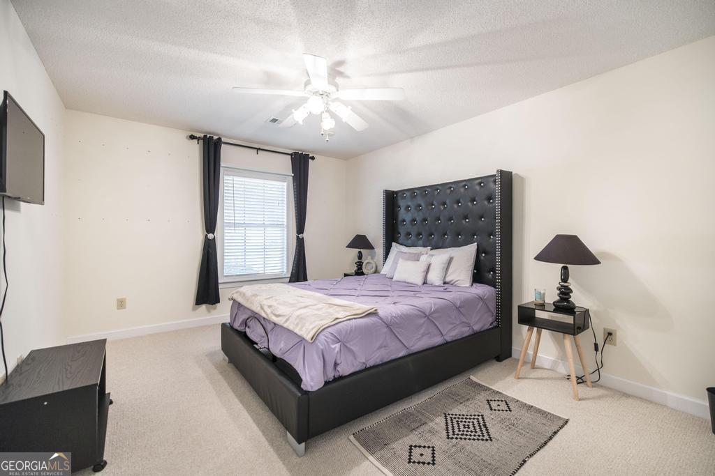 201 Strawberry Circle Dublin, GA 31021 - Photo 35 of 40 a bedroom with a bed and a chandelier