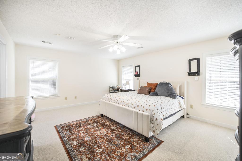 201 Strawberry Circle Dublin, GA 31021 - Photo 37 of 40 a bedroom with a large bed and a chandelier