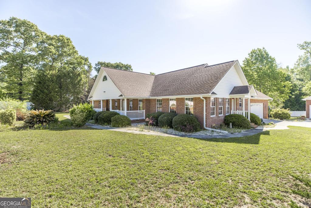 201 Strawberry Circle Dublin, GA 31021 - Photo 7 of 40 a front view of a house with a yard table and chairs