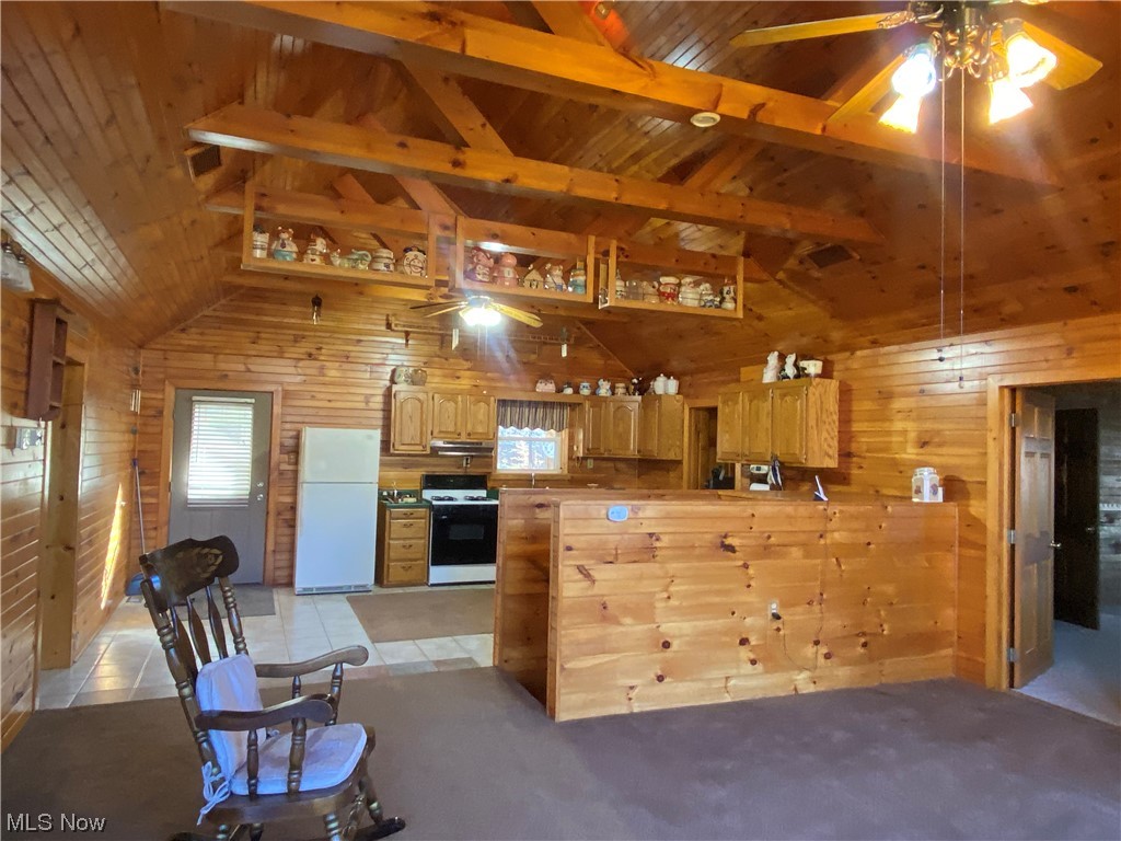 2008 Goose Creek Road Petroleum, WV 26161 - Photo 32 of 35 Kitchen with white appliances, light tile flooring, wooden walls, ceiling fan, and vaulted ceiling with beams