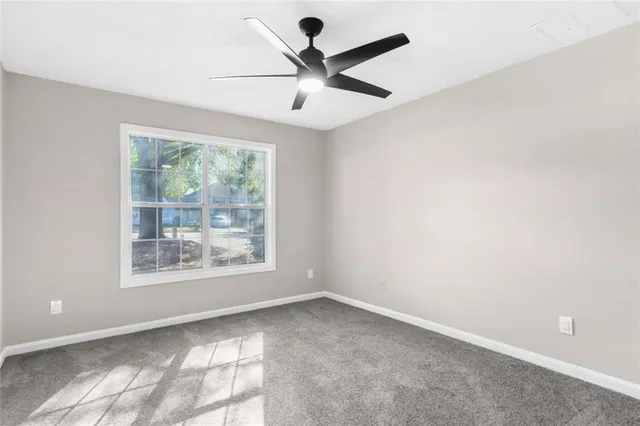 an empty room with a window and a ceiling fan