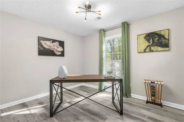 a view of a workspace with furniture and wooden floor