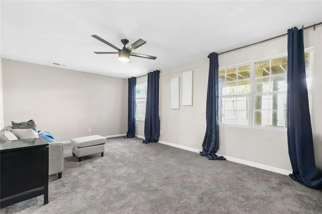 a living room with furniture and ceiling fan