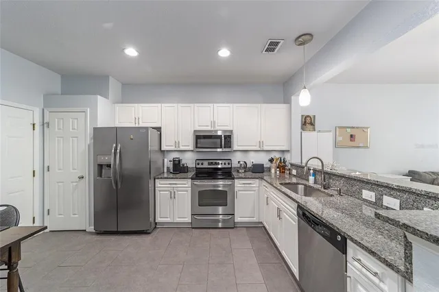 a kitchen with stainless steel appliances granite countertop a refrigerator and a stove