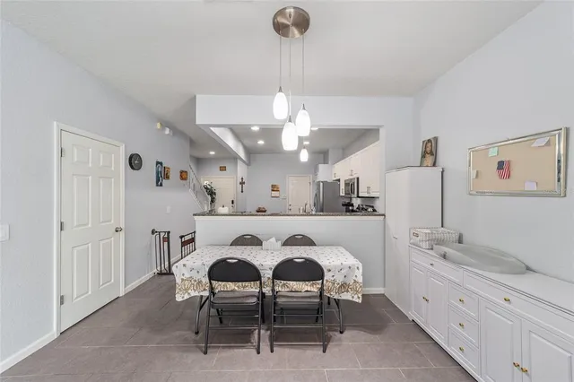a spacious kitchen with a dining table chairs sink and cabinets